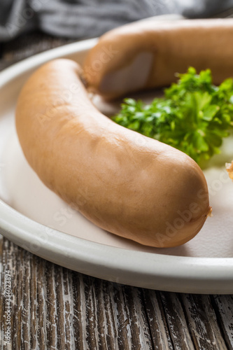 Three frankfurter on white plate.