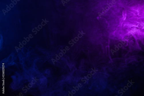 Soft clouds of colorful smoke on dark background