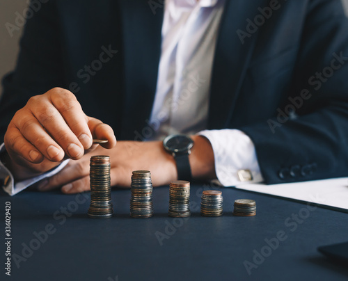 Businessman hand putting money coin stack. Successful businessman. Creative ideas for saving money concept.