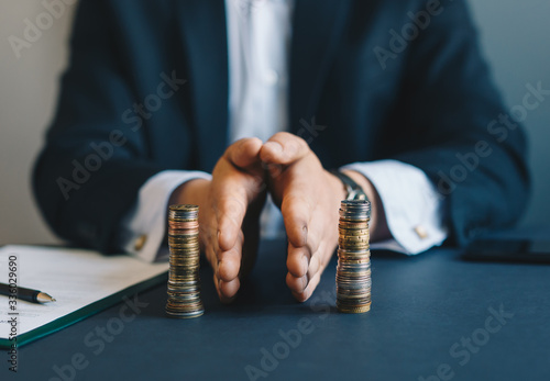 Concept of  saving and investing. Businessman separates stack coins. Property division. Divorce and legal services. photo