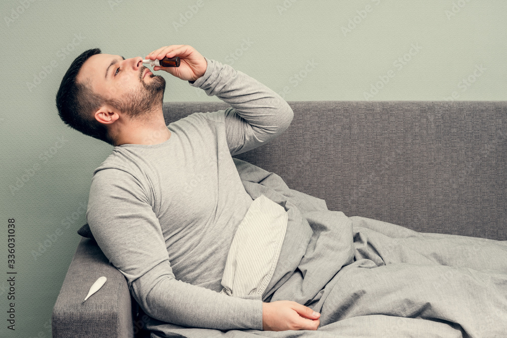 Disease. Cheer at home. A young man is sick, is treated at home. Blows her nose into a napkin, runny nose. Infection, epidemic, bacillus carrier. Disease. Cheer at home. A young man is sick, is treated at home. Blows her nose into a napkin, runny nose. Infection, epidemic, bacillus carrier.
