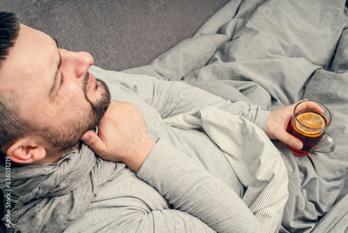 Disease. Cheer at home. A young man is sick, is treated at home. Blows her nose into a napkin, runny nose. Infection, epidemic, bacillus carrier.