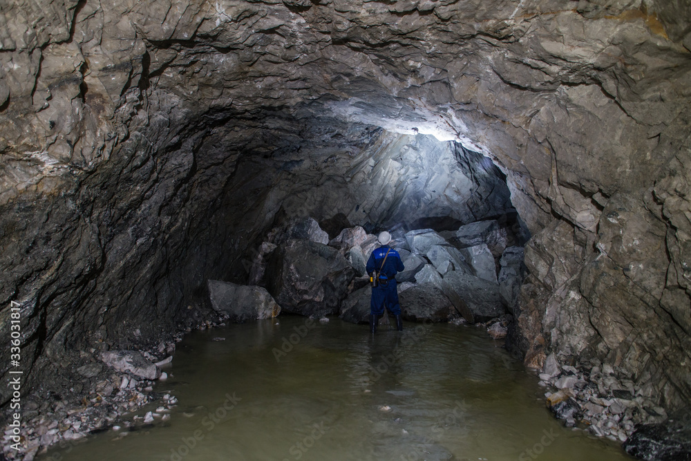Miner in underground gold quartz mine tunnel