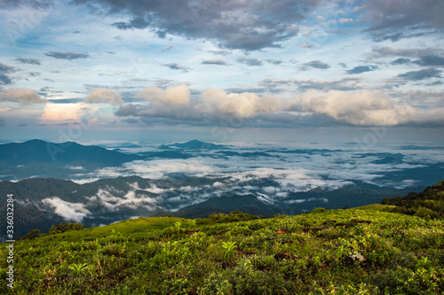 Cloud layers on mountain horizon with green grass