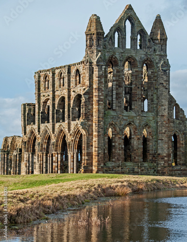 Ancient gothic english abbey with reflection in lake photo