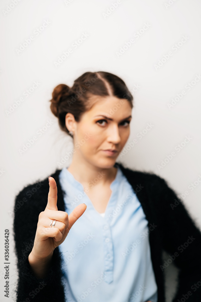 Woman shows an index finger upwards. Gesture thinking idea. Isolated on a white background Woman shows an index finger upwards. Gesture thinking idea. Isolated on a white background