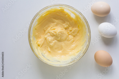 Top view of bowl with thickened custard cream and eggs on the white background