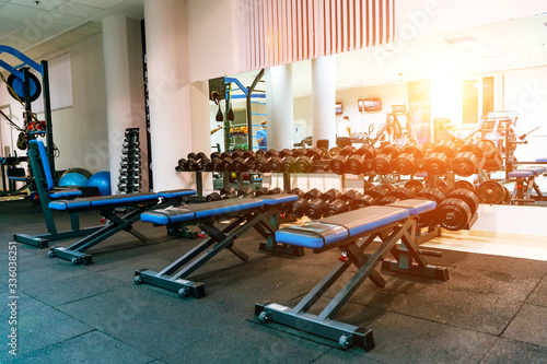 Bench in an exercise room. Equipment and machines at the modern gym room fitness center.