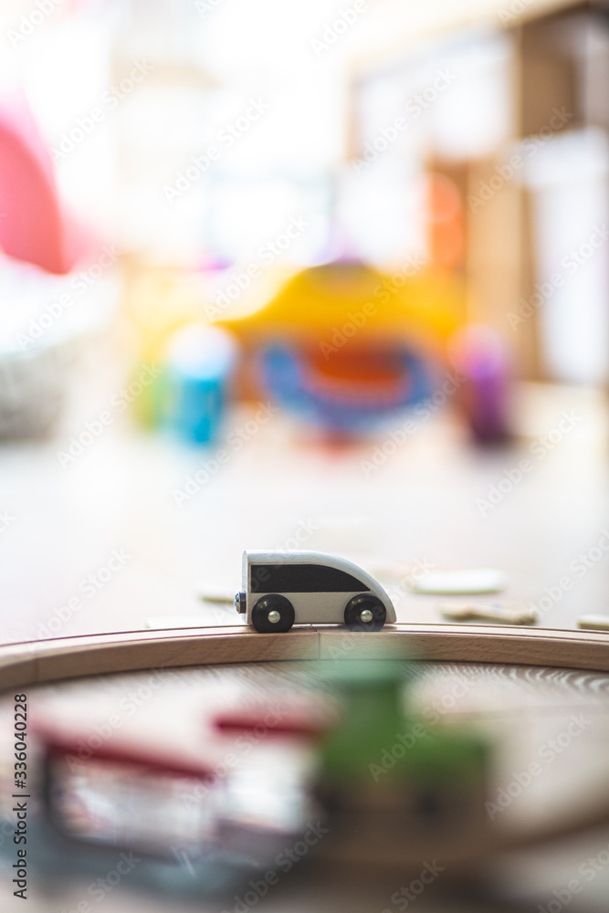 Grey toy wooden train on a railway on a floor playground Grey toy wooden train on a railway on a floor playground