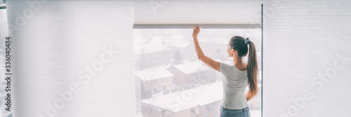 Konstfotografi Home lifestyle woman staying in opening blinds shades window treatement cellular honeycomb pleated paper curtains banner background