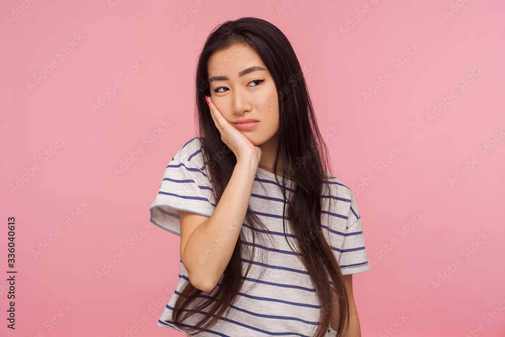 Portrait of bored lazy upset girl with brunette hair leaning on hand and looking with gloomy indifferent expression, listening to boring tedious talk. indoor studio shot isolated on pink background Portrait of bored lazy upset girl with brunette hair leaning on hand and looking with gloomy indifferent expression, listening to boring tedious talk. indoor studio shot isolated on pink background