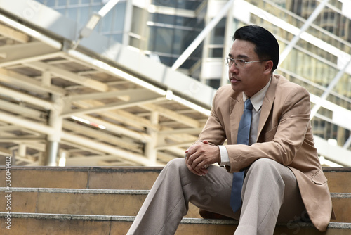 Smart business man sitting down  on the stair with city background