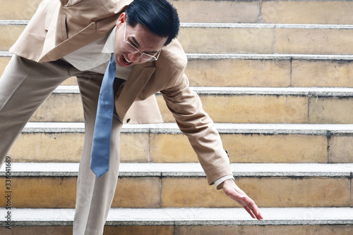 Business man with shocking face while fall down on the stair
