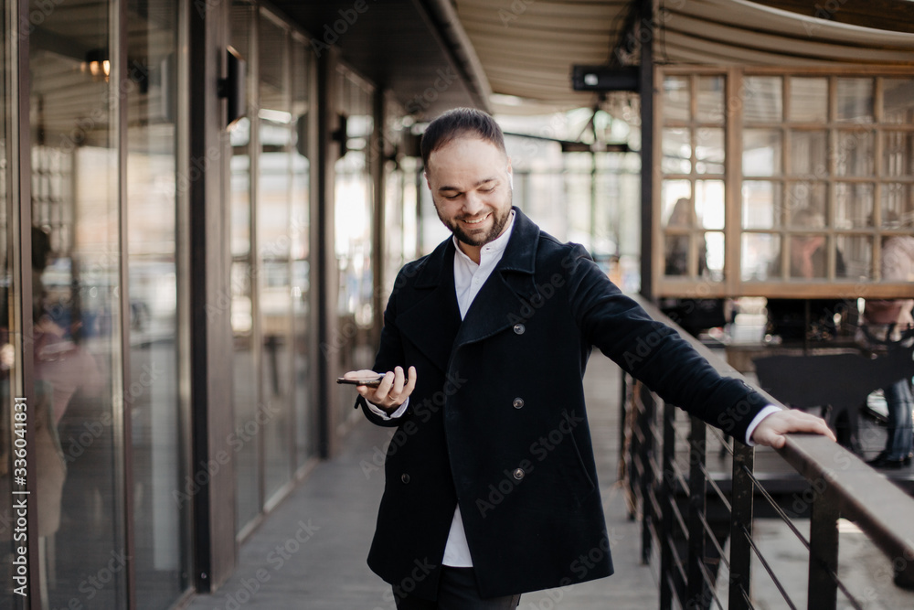 Fototapeta premium Portrait of fashionable well dressed man with beard posing outdoors