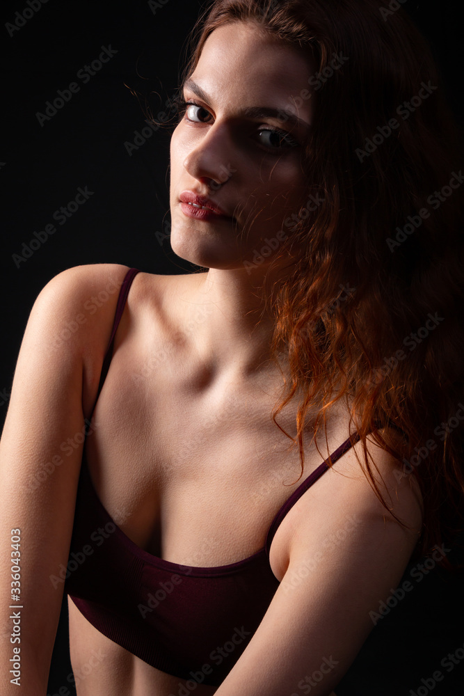 Portrait of a young curly girl in a dark studio Portrait of a young curly girl in a dark studio