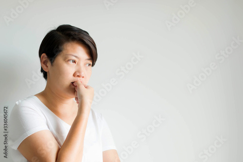 A side face of a woman feeling nervous anxious;  listless and expression by biting nail of the thumb. photo