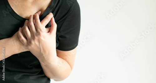 Close-up image of a woman pressing on chest with pain.