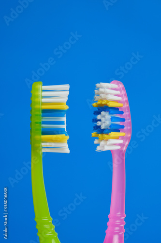 green and pink toothbrush on blue background, couple