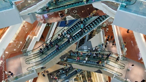 Time lapse crowd of people in shopping mall. Escalators in modern shopping mall.
