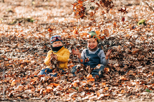 Kinder spielen im Laub im Wald 3