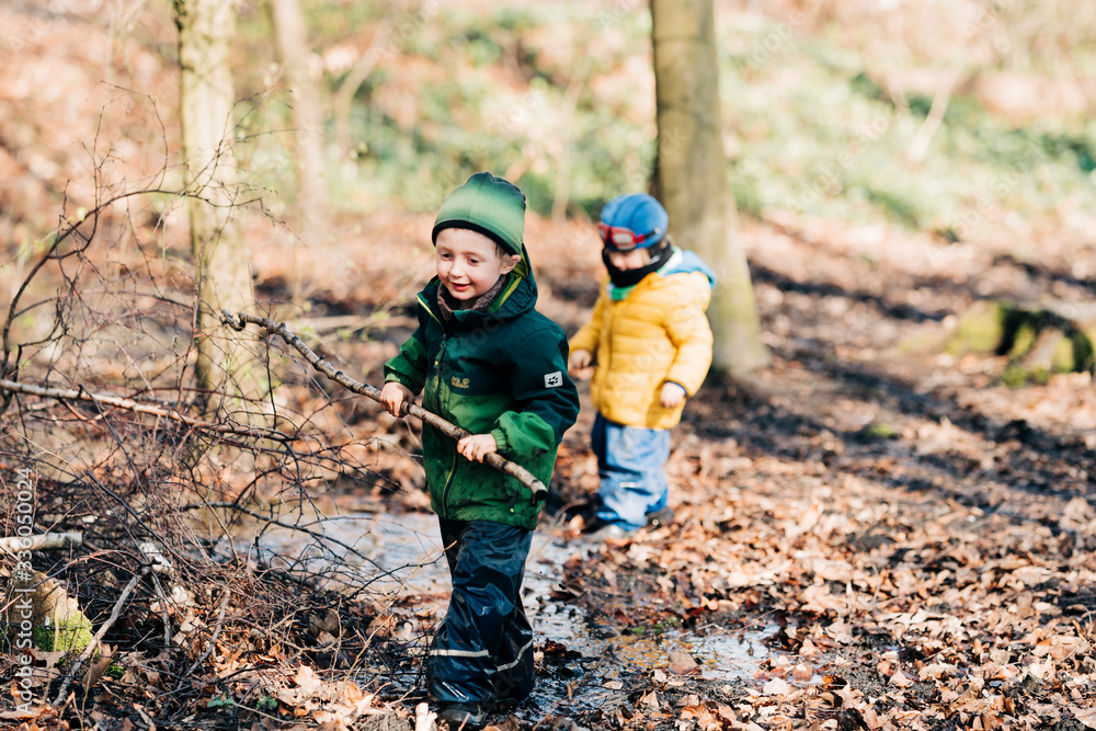 Jungen spielen mit Stöcken im Wald