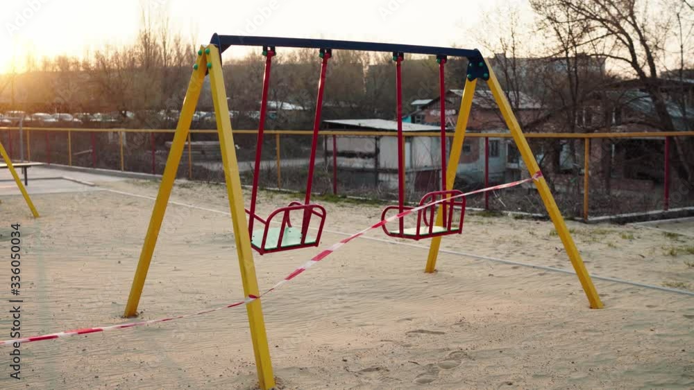 An empty abandoned playground fenced with ribbons in a residential area during quarantine due to the threat of AKA covid-19 coronavirus. Ukraine, Sumy An empty abandoned playground fenced with ribbons in a residential area during quarantine due to the threat of AKA covid-19 coronavirus. Ukraine, Sumy