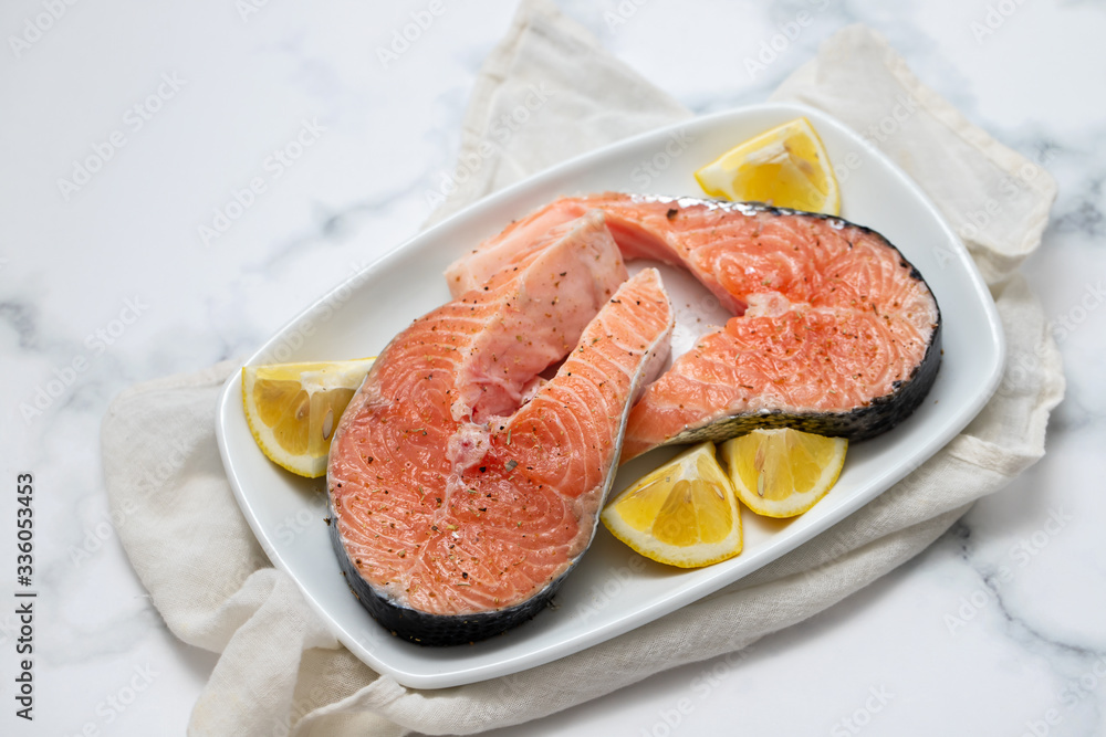 raw salmon with lemon on white dish