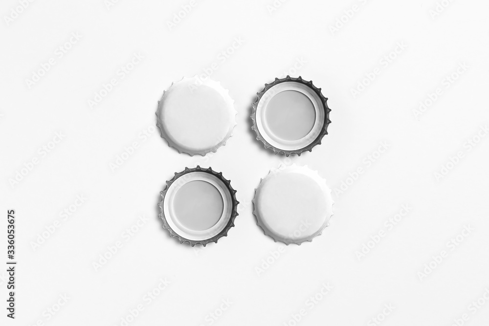 White Beer Caps Mockup isolated on soft gray background, front and backside, top view. Empty metal soda caps mockup design template.High-resolution photo.
