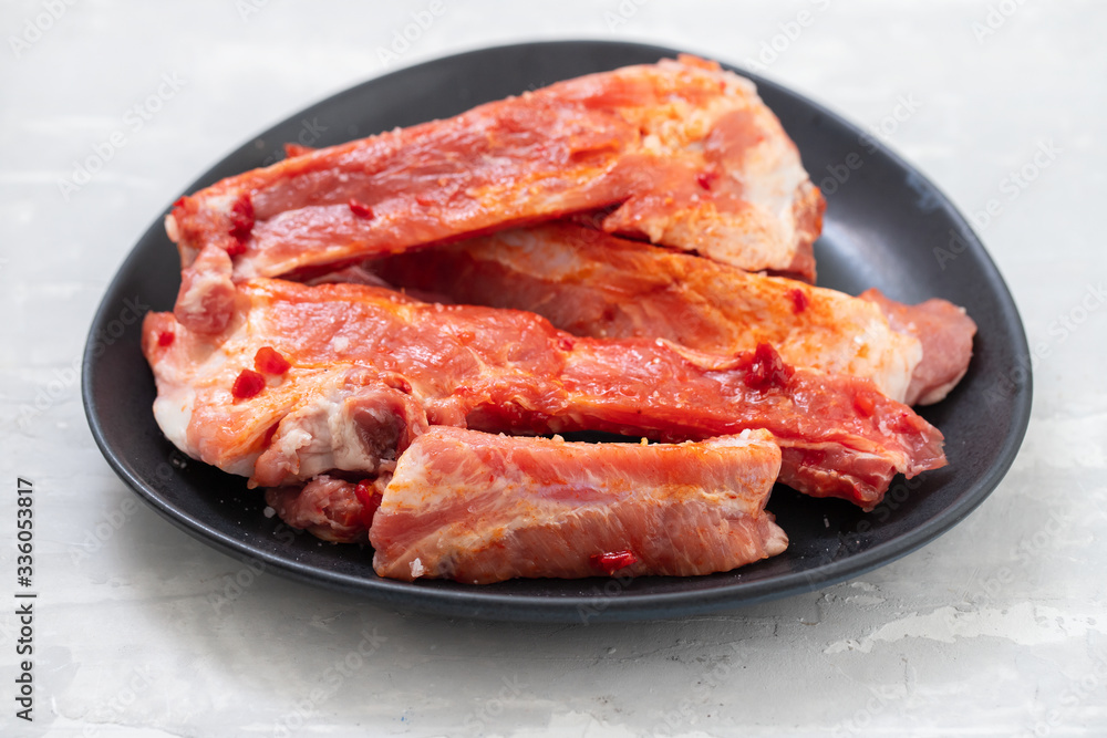 marinated meat on black dish on ceramic background marinated meat on black dish on ceramic background