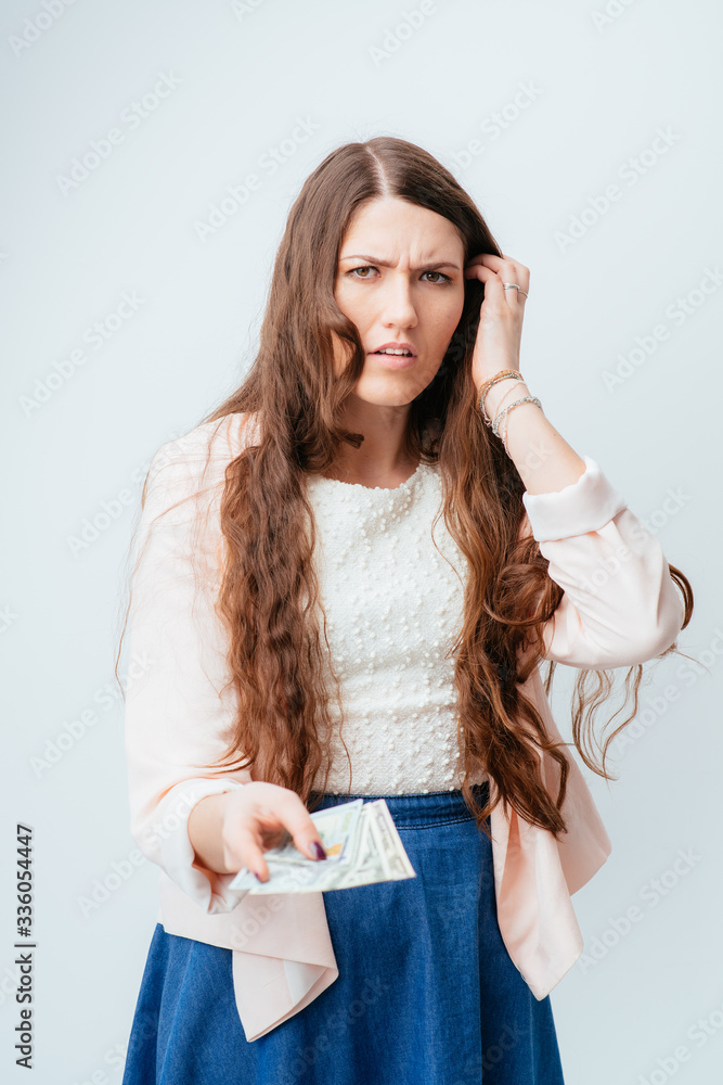 long-haired beautiful young brunette woman in blue long dress holds money in hands, received salary and considers long-haired beautiful young brunette woman in blue long dress holds money in hands, received salary and considers