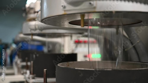 Plastic film making machine Polypropylene Closeup shows the clear plastic material flowing from the die head into a water tray with cold water to cool the plastic and make it beautiful.