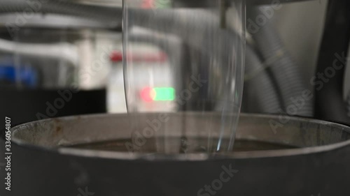 Plastic film making machine Polypropylene Closeup shows the clear plastic material flowing from the die head into a water tray with cold water to cool the plastic and make it beautiful.