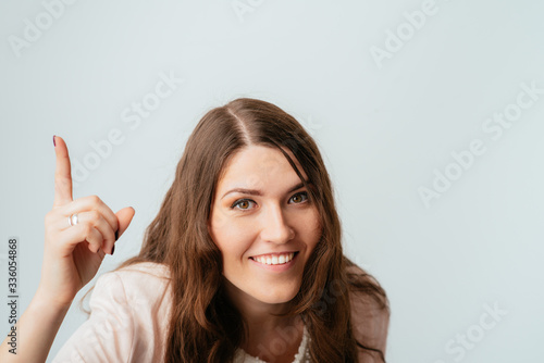 on a gray background young girl shows the index finger up