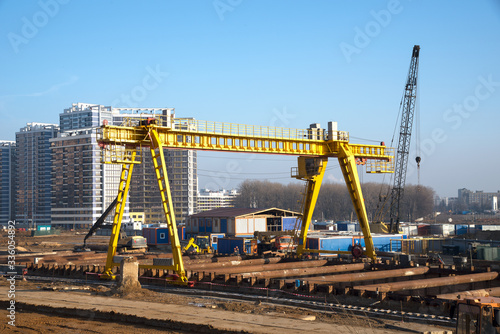 Gantry crane and auto crane working at construction site. Digging a pit for the building of an underground tunnel of the metro line. Subway construction project, Minsk, Belarus, Aerodromnaya street