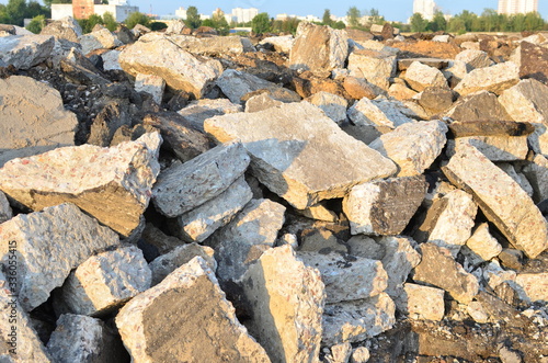 Broken pieces of asphalt at a construction site. Recycling and reuse crushed concrete rubble, asphalt, building material, blocks. Crushed сoncrete Background. Road repair, replacement of old pavement