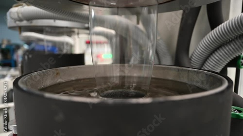 Plastic film making machine Polypropylene Closeup shows the clear plastic material flowing from the die head into a water tray with cold water to cool the plastic and make it beautiful.