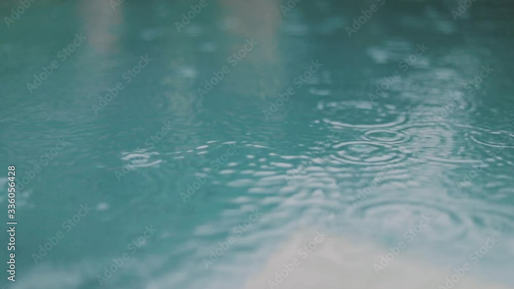Lockdown shot of rain falling on turquoise water. Close up slow motion Lockdown shot of rain falling on turquoise water. Close up slow motion