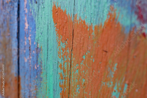 Vintage boards painted with colored paint on the peeling surface. Weathered coating of wood material.