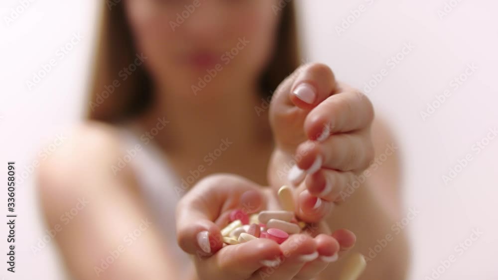 Close-up of female hands. Someone pours a bunch of prescription medical pills into the hand. Close-up of female hands. Someone pours a bunch of prescription medical pills into the hand.