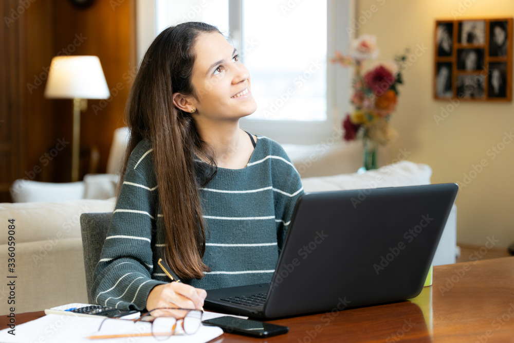 Pensive teen girl with laptop at home Pensive teen girl with laptop at home