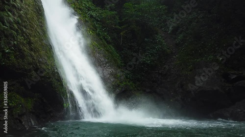 Waterfall in the rainforest jungle. Tropical Kabigan Falls in mountain jungle. Philippines, Luzon. photo