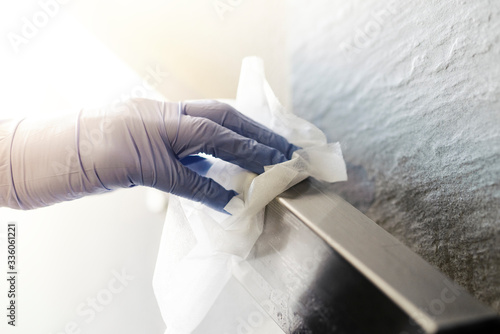 Disinfecting a bannister during the coronavirus with alcohol wipe