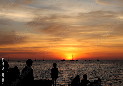 Sunset near dusk the people on the coast see many fishing boats. See in the distance