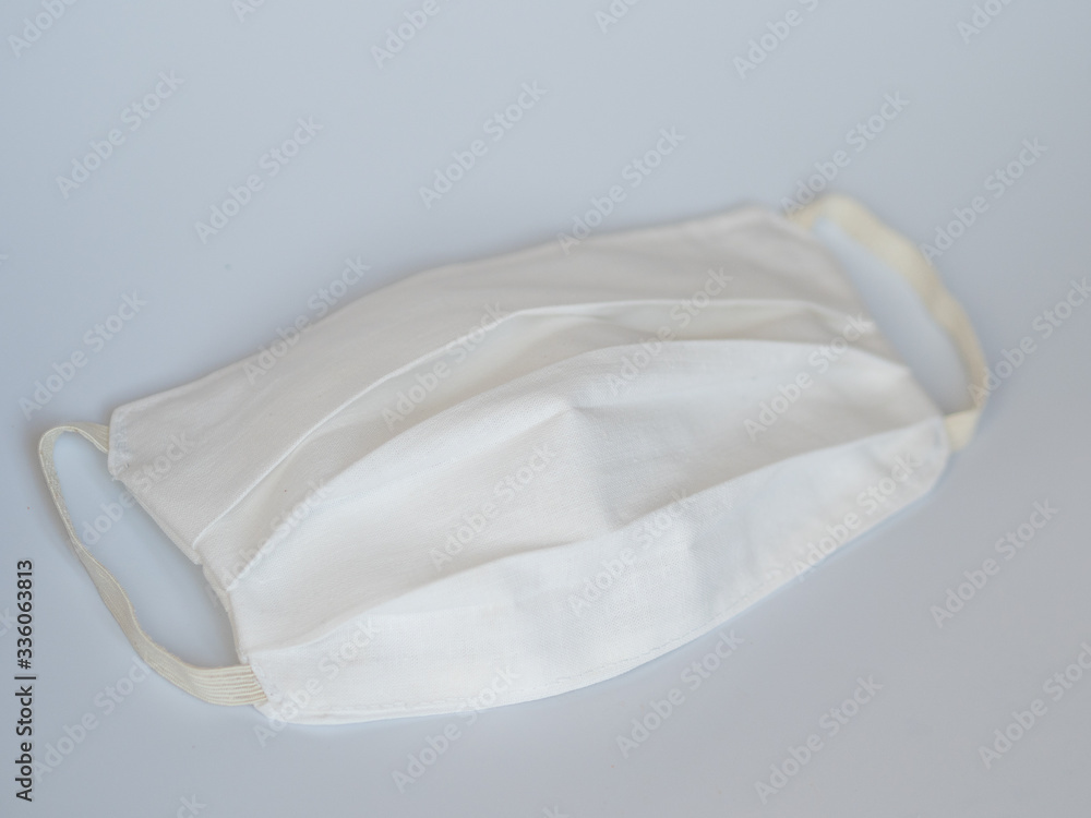 Obraz premium Sewing a protective medical mask to protect against COVID-19. Handmade (Do-it-yourself) cotton medical mask.