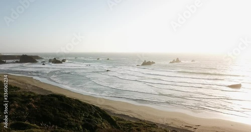 Aerial View Moving forward shot, Scenic view of the Pacific Shore in California, Sun rise in the background.