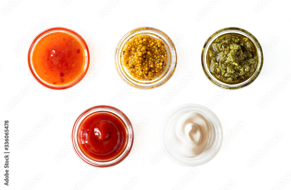 Sweet chili sauce, french mustard, basil pesto, ketchup and mayonnaise in glass bowls isolated on white background, top view. Various seasoning and dip border Sweet chili sauce, french mustard, basil pesto, ketchup and mayonnaise in glass bowls isolated on white background, top view. Various seasoning and dip border