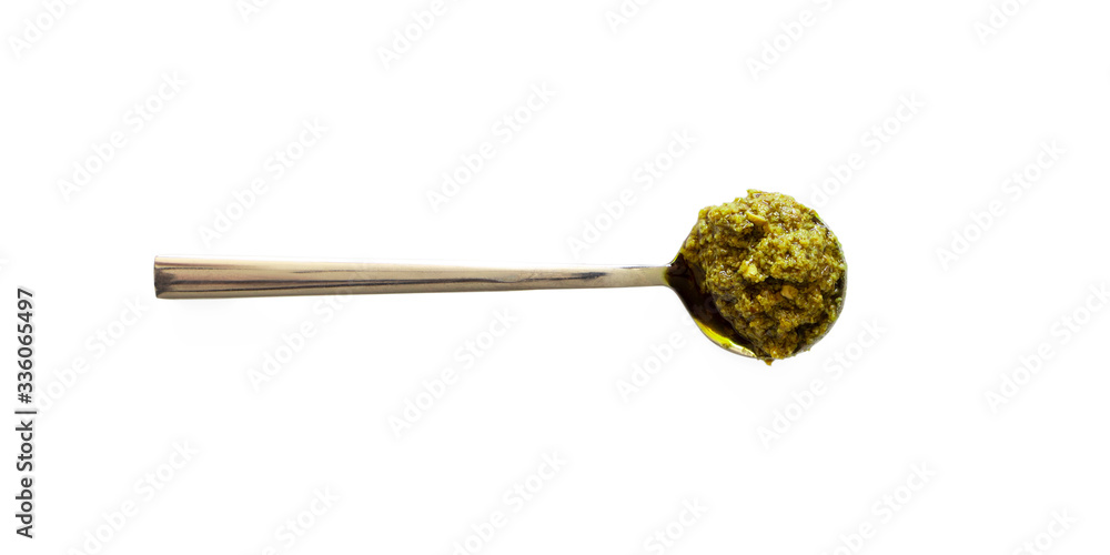 Spoon with pesto isolated on white background, top view. Close-up basil italian sauce Spoon with pesto isolated on white background, top view. Close-up basil italian sauce