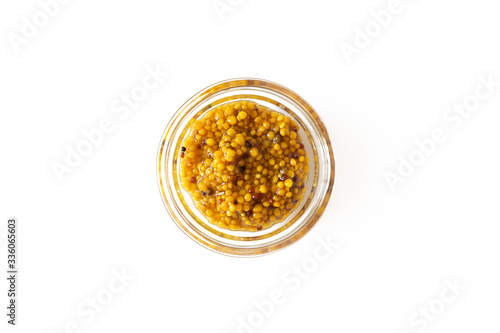 French mustard sauce in glass bowl isolated on white background, above. Seasoning and dip