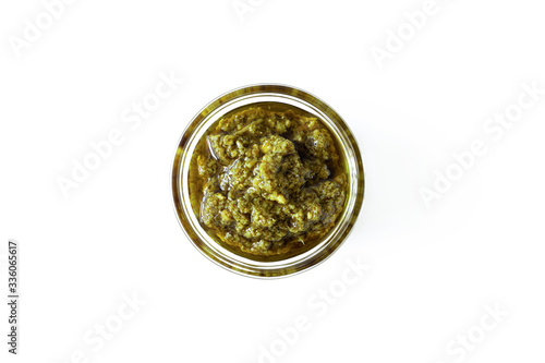 Basil italian pesto sauce in glass bowl isolated on white background  above. Seasoning and dip