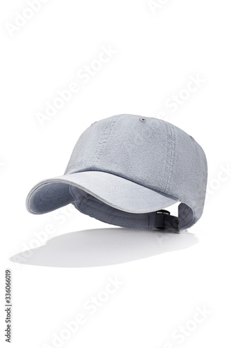 Subject shot of a gray-blue denim baseball cap with a stitch on the visor, vent holes and a back fastener. The unisex headwear is isolated on the white background.